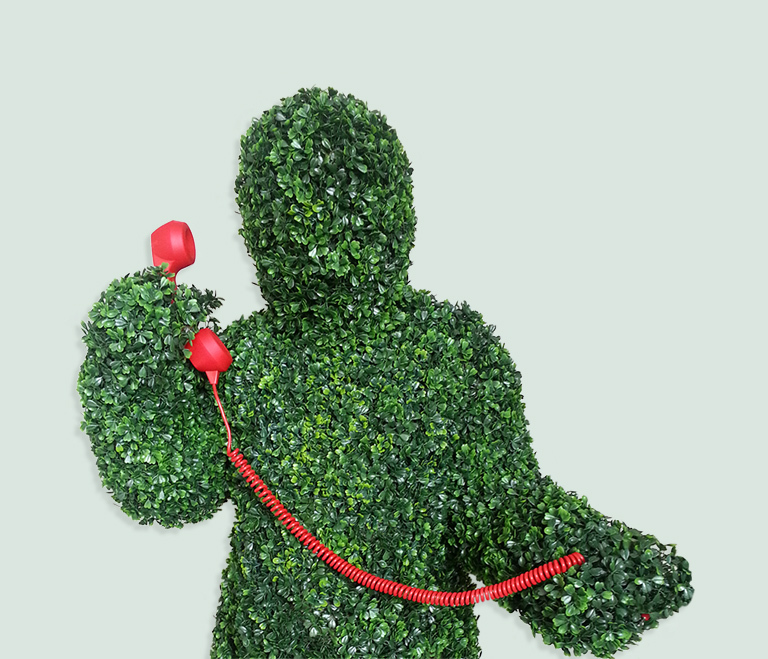 A Hedge Man performer posing with a telephone.
